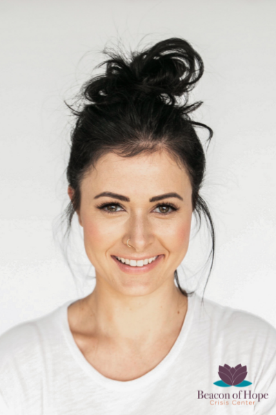Woman smiling, hair in a messy bun