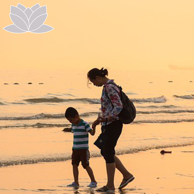 Woman and son walking on the beach.